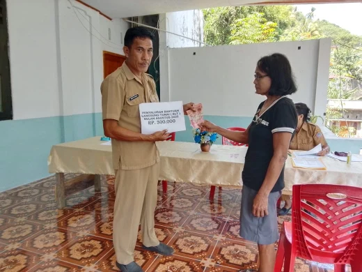 Kapitalau Kampung Batubulan tengah menyerahkahkan BLT.